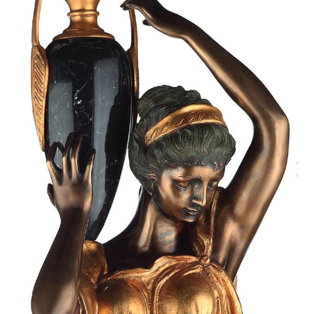 Pair of bronze and marble sculptures depicting a girl with an amphora, 21st century, H: 113 cm The piece is often made of...