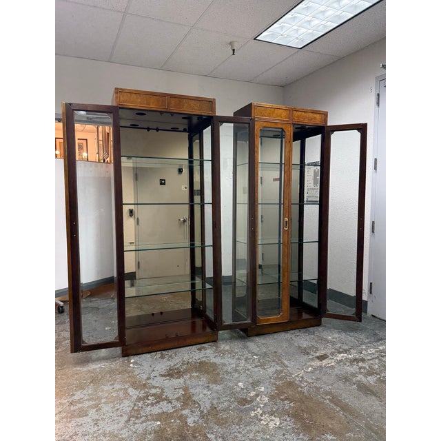 Design Plus Gallery presents a Pair of Vintage Campaign Style Curio Display Cabinets. Each cabinet is detailed with burled...