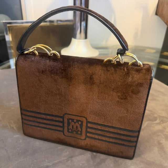 A stylish 1980s Italian handbag by Morando, crafted with a rich brown velvet body and black leather trim. The front flap...