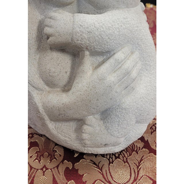A mid-century stone sculpture modeled after Rima Padova of a mother and child. Probably made of limestone with some...