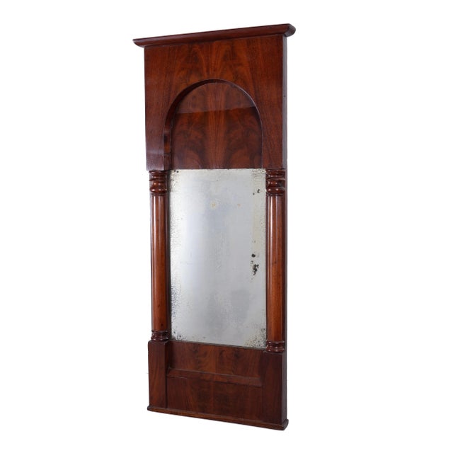 Biedermeier mahogany and crotch mahogany veneered pier mirror with cornice above a paneled and arched entablature. The...