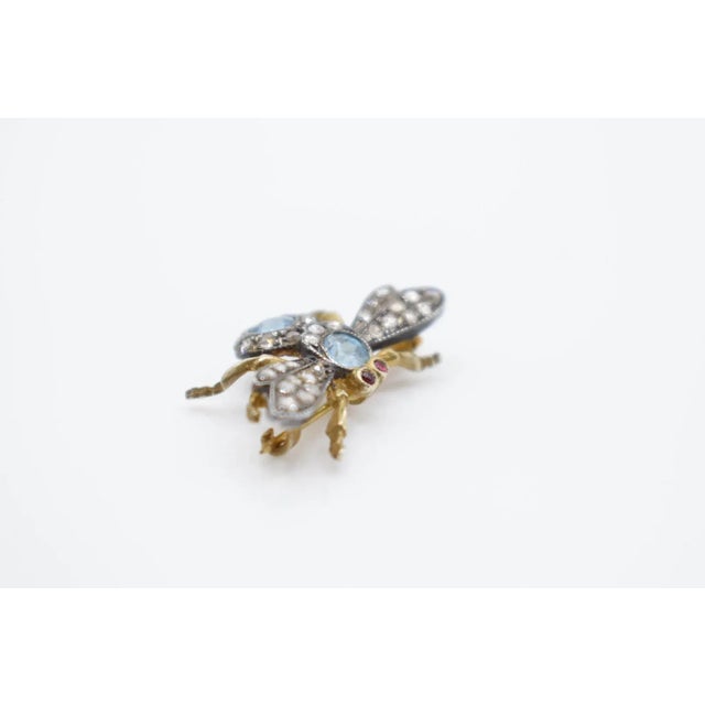 This is a fun brooch that depicts a bug. It has blue zircon, silver, and gold. It is able to be a brooch or a pendant. no...