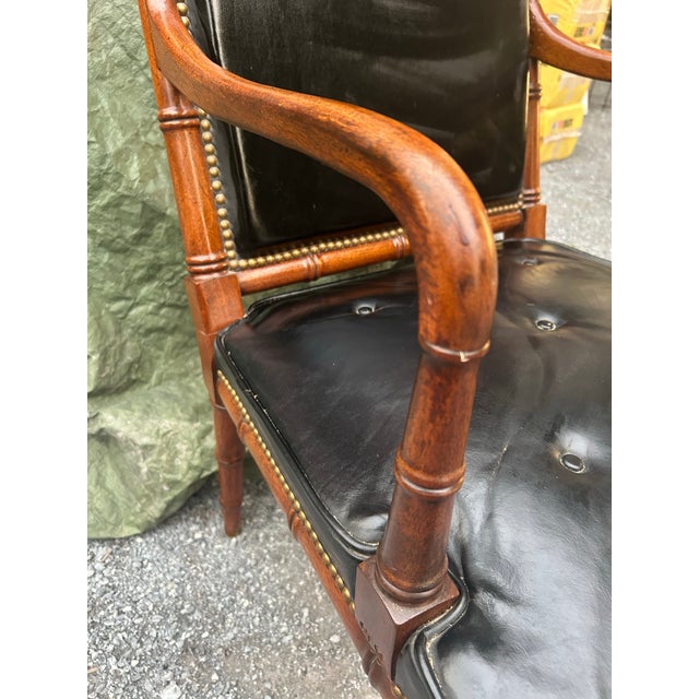 A striking mid-century Hollywood Regency-style revival armchair exhibiting exceptional bench-made craftsmanship. The dense...