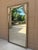 An elegant Hollywood Regency giltwood mirror featuring carved trompe l'oeil faux drapes over a mirror, in a beautifully...