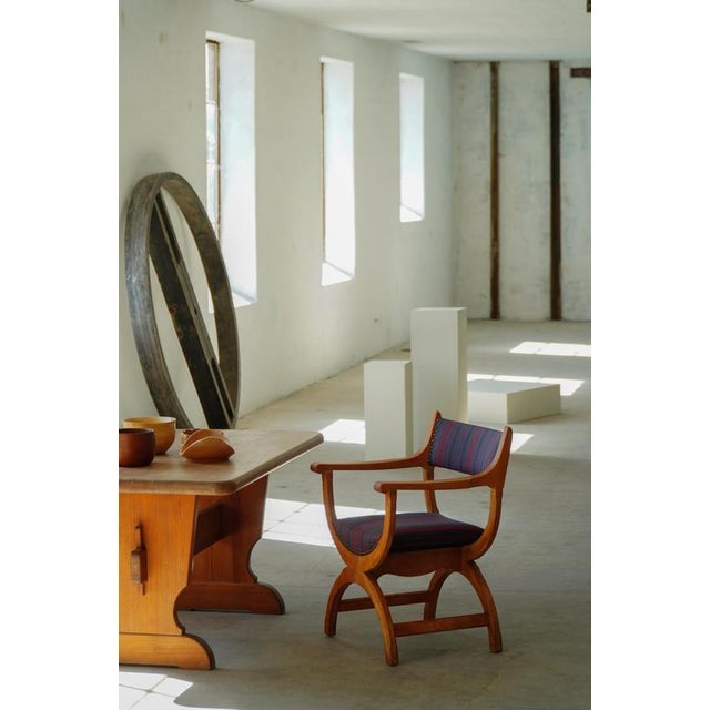 A beautiful pair of Danish armchairs crafted in solid oak and upholstered in an elegant striped textile in deep burgundy,...