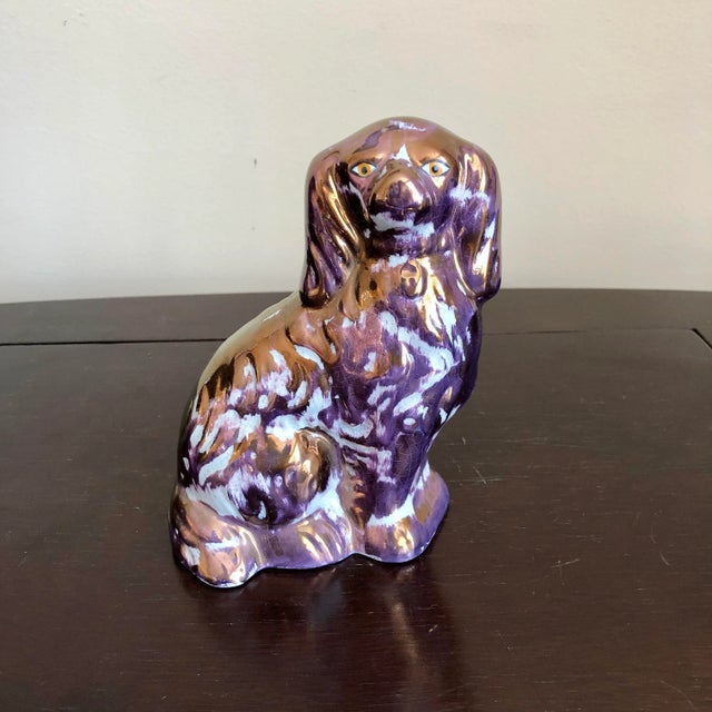 A pair of antique purple lusterware Staffordshire spaniels.