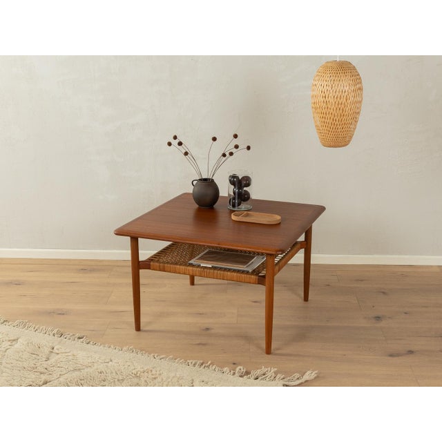 Model 214 coffee table from the 1960s by Kurt Østervig for Jason Møbler. High-quality solid teak frame with a woven reed...