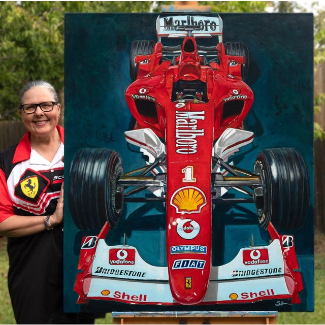 This artwork presents a striking overhead view of the iconic Ferrari F2004, rendered in vibrant red acrylics that capture...