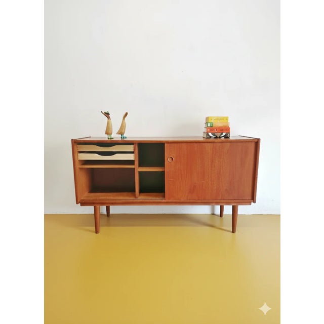 A vintage Danish teak sideboard from the 1950s with sliding doors and drawers, featuring a simple and elegant design,...