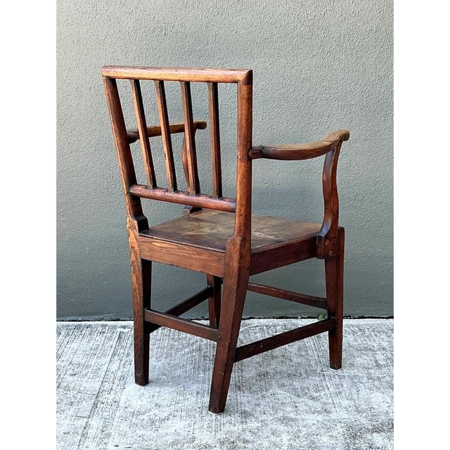 This George III country house "elbow" armchair is a fine representation of 18th-century English joinery, distinguished by...