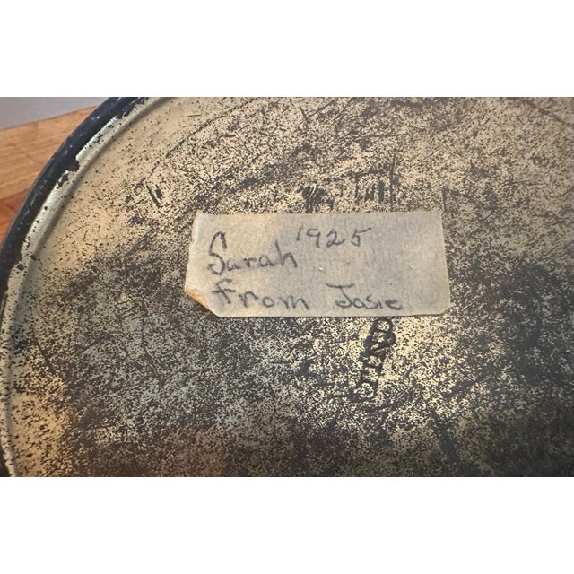 This Charming vintage round tin featuring a soft, painterly floral motif in muted greens, creams, and warm peach tones is...