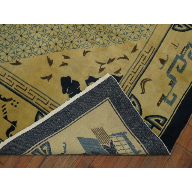 A mid 20th century room size Chinese rug in blue and yellow. The wool and feel of the rug is very soft on the feet. It has...