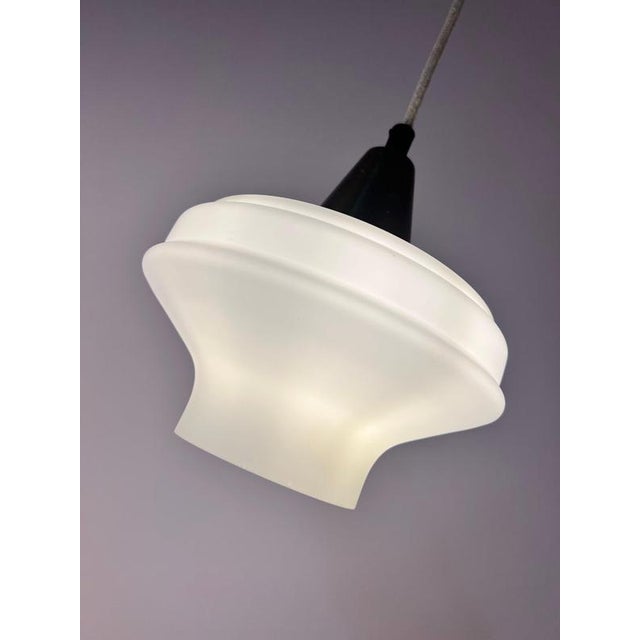 An elegant balance of cool glass and warm metal tones characterizes this pendant lamp from Denmark. Designed in the 1960s,...