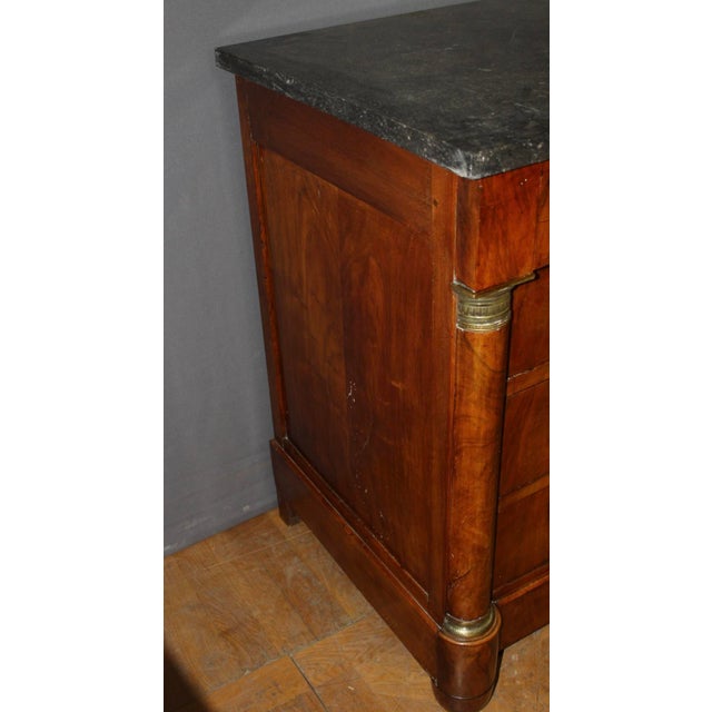 Empire-style walnut commode with a half-column top and a Belgian Granité marble top. It features four drawers and its...