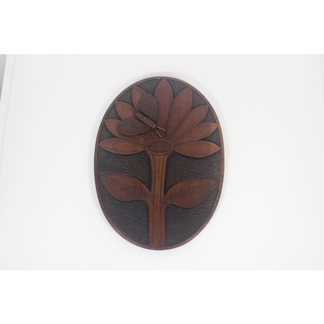 Oval Mid century hand carved wood wall plaque with a large flower and bee or butterfly. Great texture. Has a hole on the...