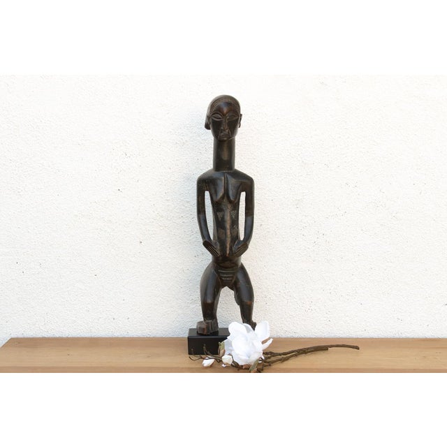 The Silent Guardian" is a rare and evocative example of West African tribal sculpture. Hand-carved from a single block of...