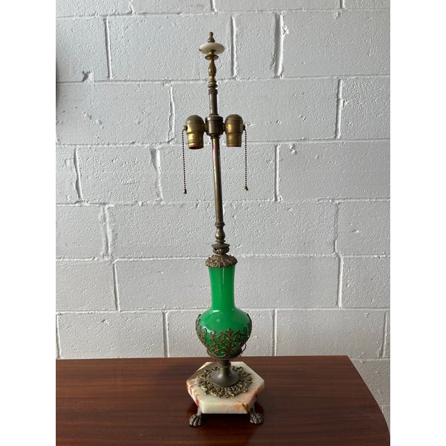 A striking antique French Louis XVI–style table lamp featuring a vibrant green opaline glass body adorned with ornate gilt...