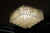 A large square pendant lamp composed of six rows of rectangular glass prisms suspended at varying heights in a cascading...