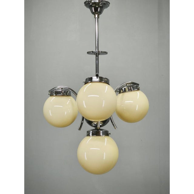 Original Art Deco chandelier produced in Czechoslovakia during the 1930s. Featuring four elegant light champagne glass...