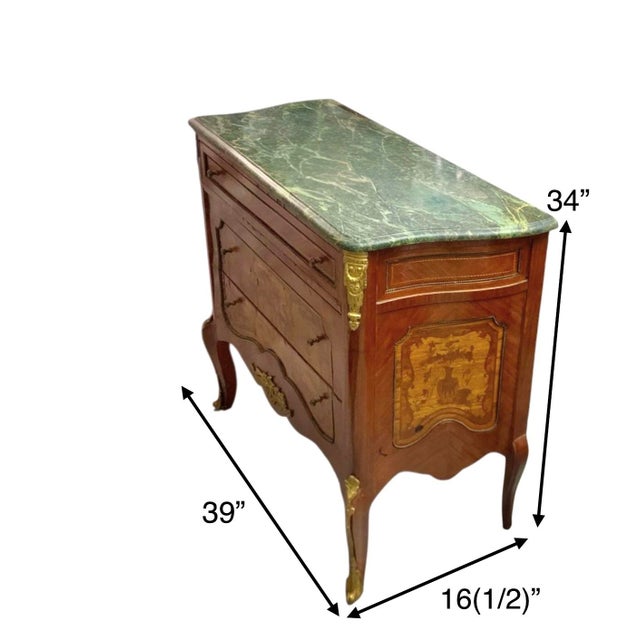 The Chest is an antique commode featuring intricate ormolu mounts and a green marble top. The chest exudes a classic...