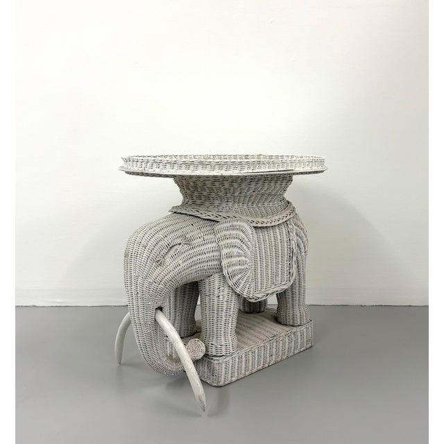 A whimsical vintage elephant-form table intricately constructed from woven rattan and finished in white. The sculptural...
