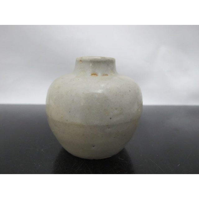 Antique, possibly Southeast Asian celadon tone pottery. Small jarlet with bulbous body. Measures 2 3/4" tall x 2 1/2"...