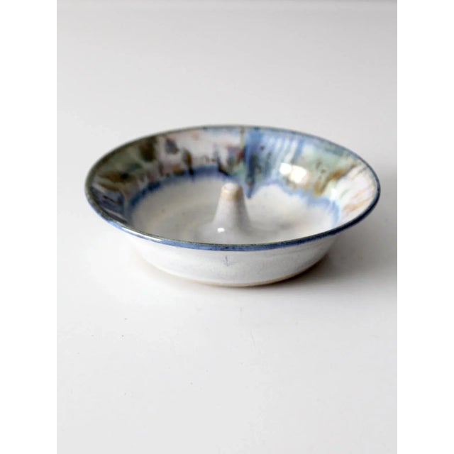 This vintage handmade studio pottery apple baker bowl features a wide, shallow form with a raised center post for baking...