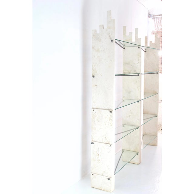 Simply a unique wall unit which has distinct elements of travertine supporting the floating glass shelves. The traverine...