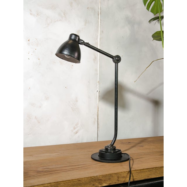 A two-arm industrial machine lamp by philips, made in the netherlands, mounted on a brake disc base. An original vintage...