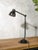 A two-arm industrial machine lamp by philips, made in the netherlands, mounted on a brake disc base. An original vintage...