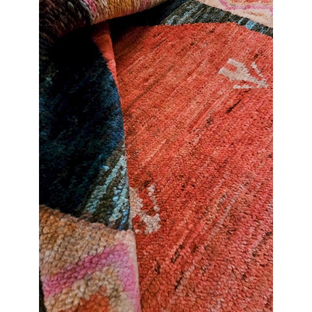 This extraordinary hand-knotted wool Afghan rug features a design reminiscent of traditional Moroccan Berber rugs. The...
