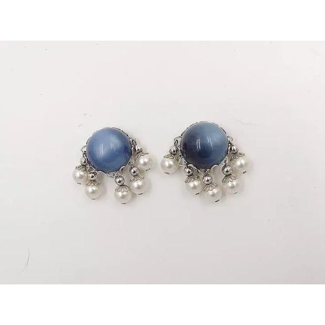 1950s silvertone blue moonglow cabochon Lucite and resin-faux pearl dangles clip back earrings. Marked "Napier."...