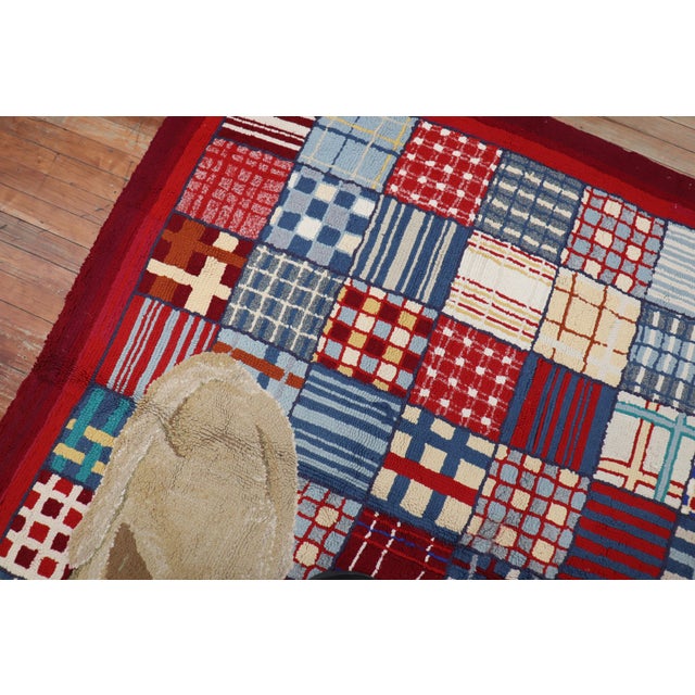A handmade American hooked rug from the middle of the 20th century depicting 2 large dogs on all over square plaid...