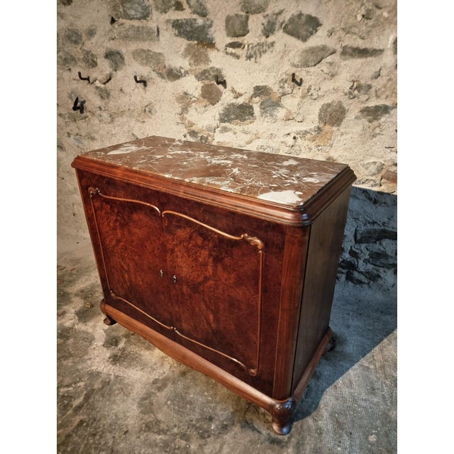 This sideboard was made in France in the late 1920s. It is constructed from walnut and mahogany, with finely patterned...