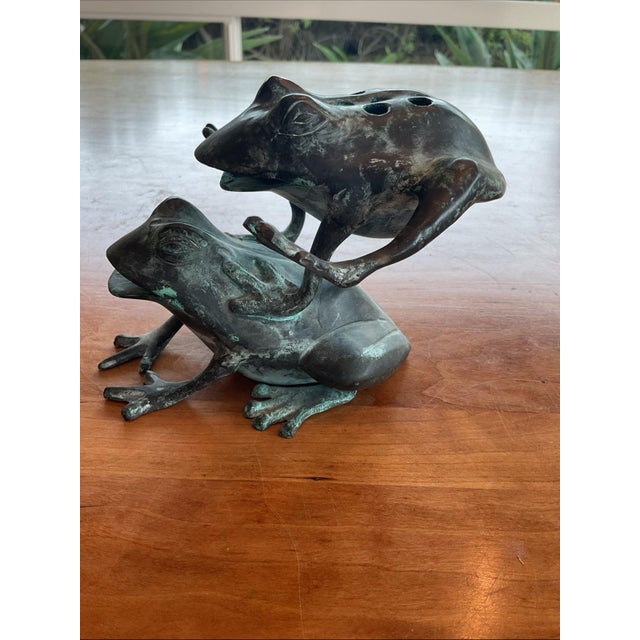 Whimsical vintage solid cast brass frog sculpture designed as a functional flower frog. The top features multiple stem...
