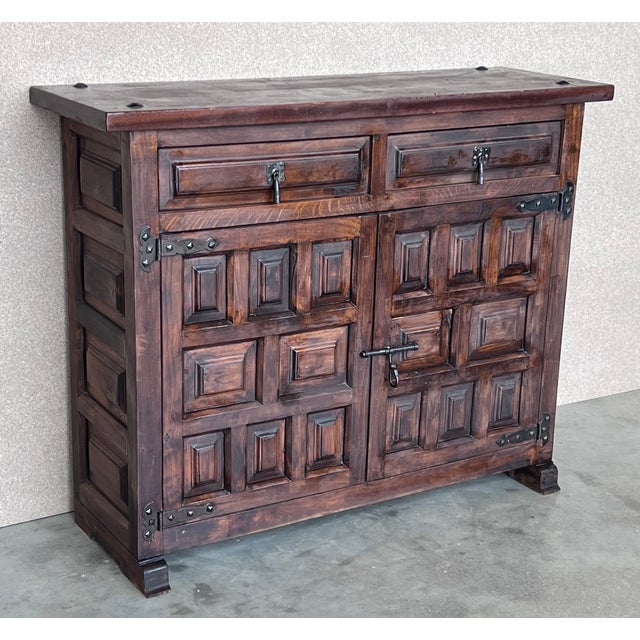 From Spain, constructed of solid walnut, the rectangular top without edge top, conforming case housing two carved drawers...