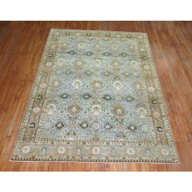 A small room size early 20th century Persian Veramin rug featuring birds floating on a sky blue ground and orange vorder....