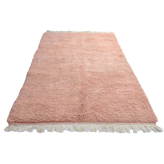 Moroccan rug handwoven with blush pink high pile wool with ivory fringe at both ends. Dimensions: 5'6 x 8'10