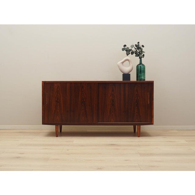The cabinet was made in the 1970s by the Danish manufacturer Hundevad & Co. The structure is covered with rosewood veneer....