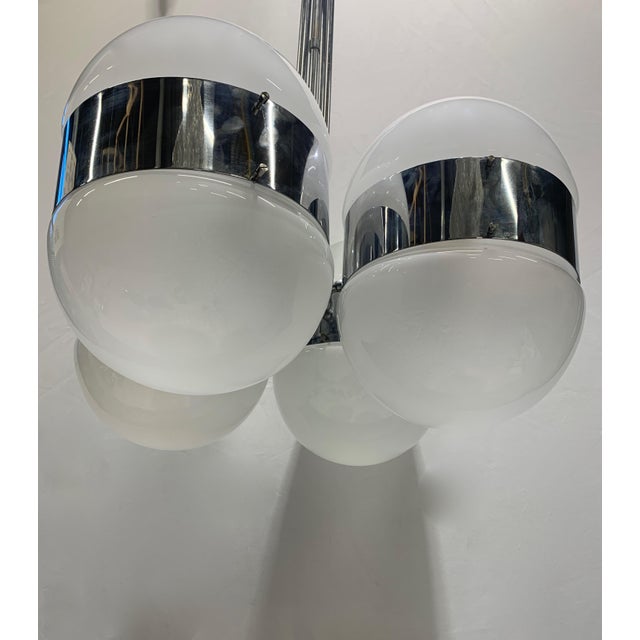 Space age style suspended chandelier, also called "tetraclio", made with a central structure in polished chromed metal...