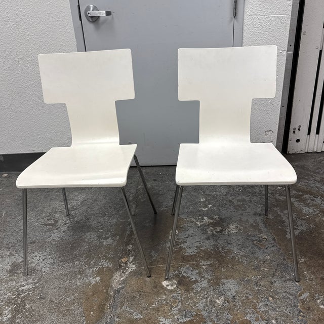 Design Plus Gallery presents a Pair of Modern Side Chairs. The chair showcases a white molded plywood shell with an...