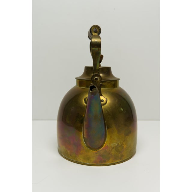 An antique late Victorian era brass kettle featuring a handcrafted wooden handle and finial, rounded belly, and gooseneck...