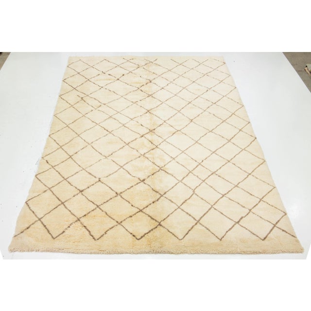 A stunning contemporary Moroccan-style wool rug, meticulously hand-knotted with a beige base and complemented by brown...