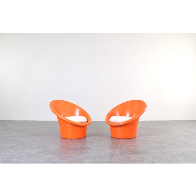 This set of two orange lounge chairs „Skopa” model was designed in the 1970s by renowned Danish designers Ole Gjerløv-...