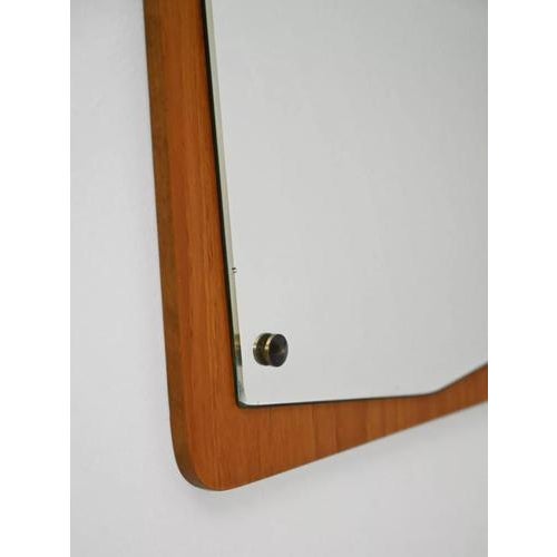 Beautiful wall mirror with a rectangular solid teak frame and a shaped internal mirror secured with metal spacers, a...