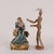 Polychrome porcelain sculpture depicting motherhood. Bronze base with shell-shaped feet. Engraved signature of the author...