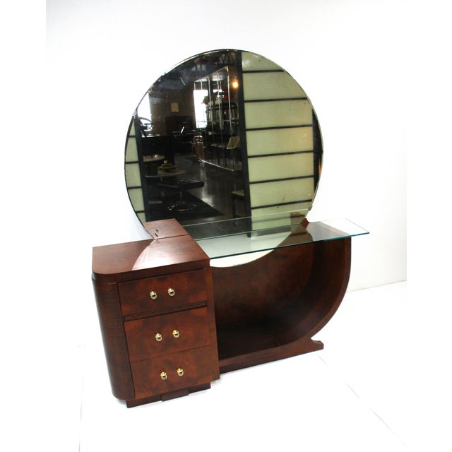 A luxurious dark mahogany vanity with round mirror, three drawers the top one with a pull up mirror and make up storage....