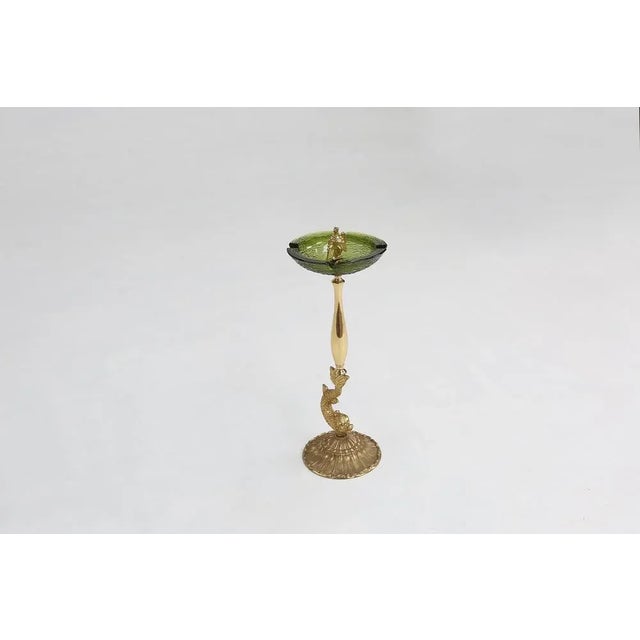 Vintage ashtray made of metal and green glass. with some nice sculpture of a fish in the base and a eagle in the top.