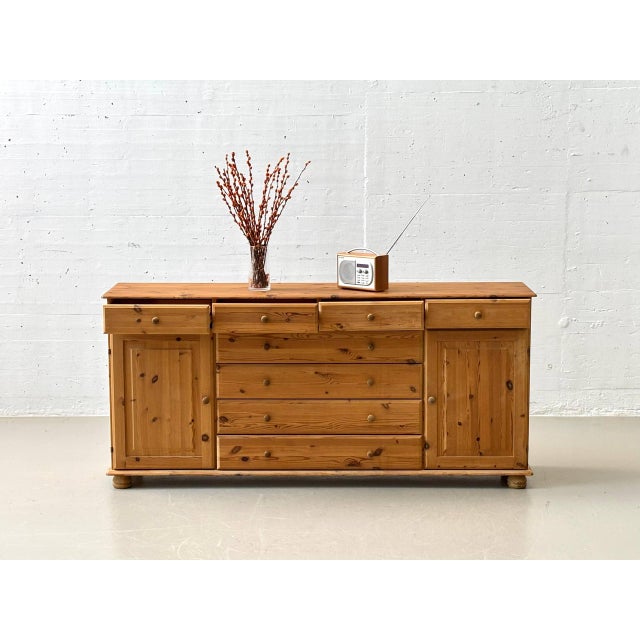 Charming sideboard made of solid pine with a characteristic grain and visible knots, typical of the rustic Swiss country...