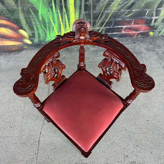 Pair of renaissance style corner chairs. These are carved out of mahogany and feature ornate details and carved faces on...